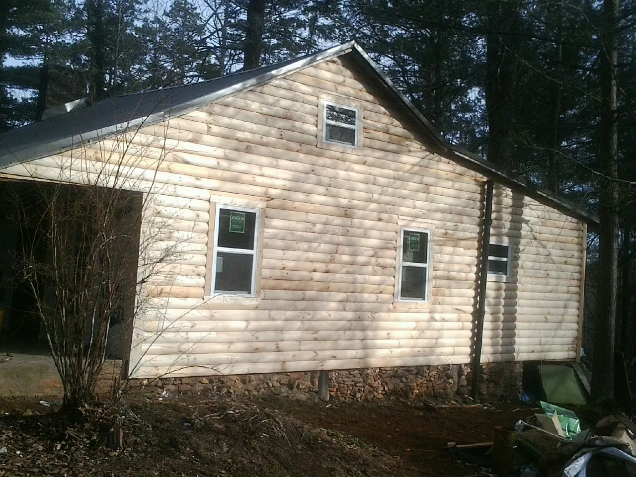 New log siding and dark metal roofing on a gable end in Crescent